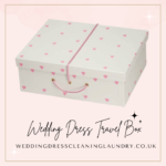 a white box with pink hearts on it. White wedding dress travel box with pink hearts, ideal for travel and storage.